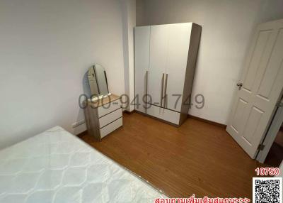Cozy bedroom with wooden flooring, white wardrobe and dressing mirror