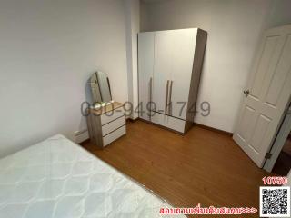 Cozy bedroom with wooden flooring, white wardrobe and dressing mirror