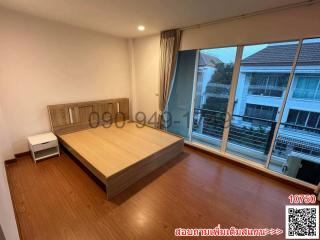 Spacious bedroom with wooden flooring and large window