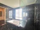 Modern bathroom with black marble finish and Jacuzzi tub