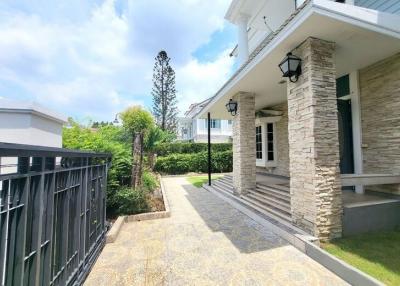 Elegant home exterior with stone cladding and paved pathway