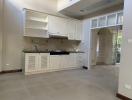 Spacious kitchen with white cabinetry and modern appliances