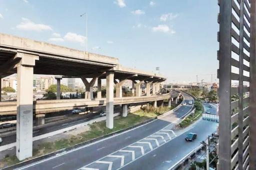 Highway view from an apartment window showing busy traffic lanes