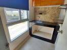 Compact kitchen with wooden cabinets and natural light