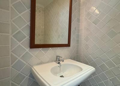 Compact bathroom with pedestal sink and tiled walls