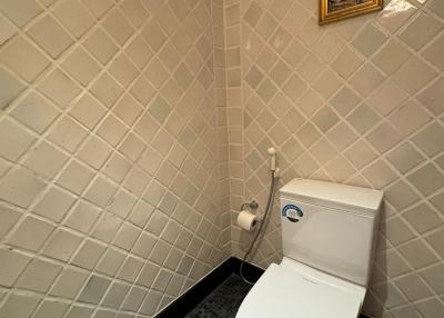 Compact bathroom with white wall tiles and patterned flooring