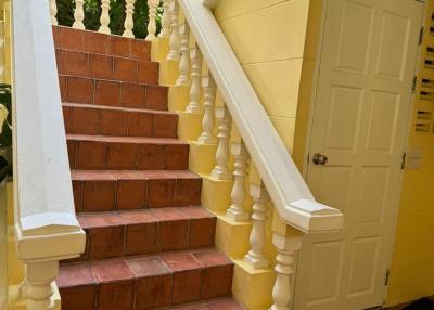 Bright staircase with terracotta tiles and yellow walls in a residential building