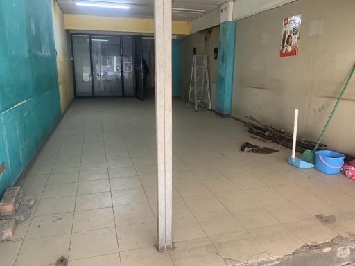 Empty commercial space with tiled flooring and a column in the center