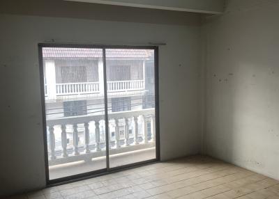 Empty room with tiled flooring and large window providing natural light
