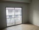 Empty room with tiled flooring and large window providing natural light