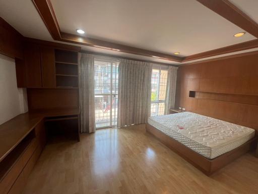 Spacious bedroom with large bed and wooden furnishings