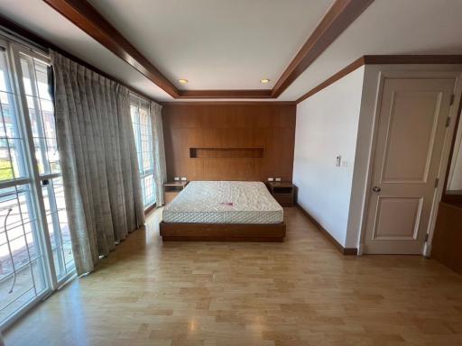 Spacious bedroom with hardwood floors and large windows