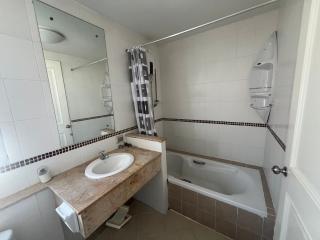 Spacious Bathroom with Tub and Shower Curtain