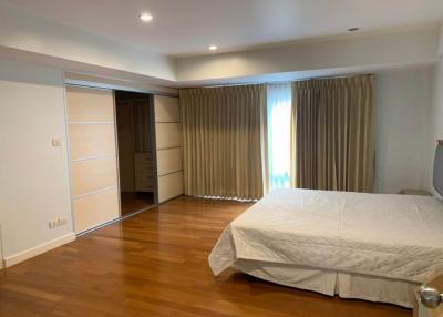 Spacious bedroom with hardwood floors and built-in wardrobe
