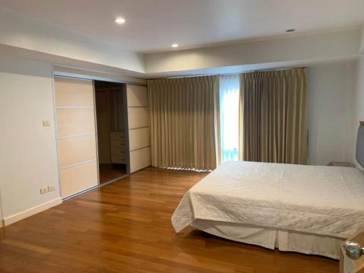 Spacious bedroom with hardwood floors and built-in wardrobe