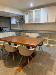 Modern kitchen with dining area, featuring wooden table and chairs