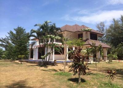 Spacious two-story house with large surrounding yard and tropical landscaping