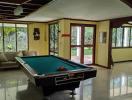 Spacious recreational room with pool table and hardwood flooring