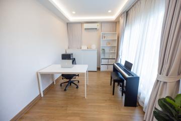 Spacious bedroom with a work desk and piano