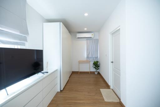 Modern bedroom with clean design, ample lighting, and hardwood floors