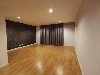 Spacious living room with hardwood floors and patterned accent wall