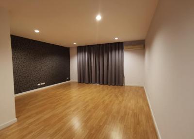 Spacious living room with hardwood floors and patterned accent wall