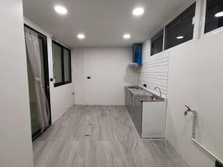 Modern small kitchen with gray flooring and white subway tile backsplash