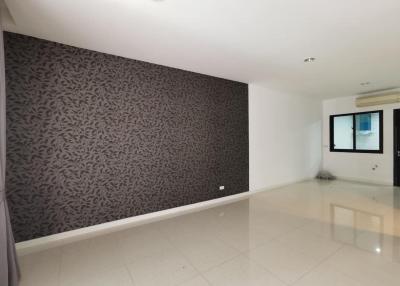 Spacious and bright living room with patterned accent wall and glossy floor