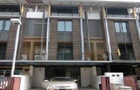 Modern multi-story residential building with a parked car in front