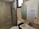 Modern bathroom with glass shower and mosaic tile wall