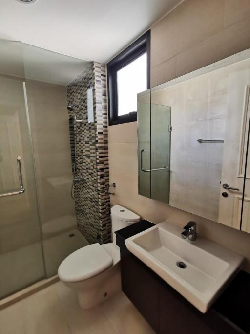 Modern bathroom with glass shower and mosaic tile wall