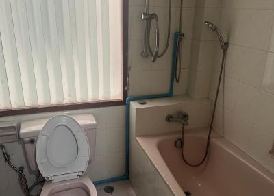 Compact bathroom with toilet, shower, and bathtub