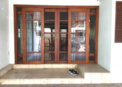 Spacious entrance with wooden double doors and tiled flooring