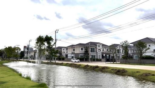 Luxurious suburban neighborhood with houses by a pond with fountain
