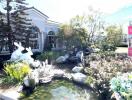 Exterior view of a house with a garden pond and ornamental figures