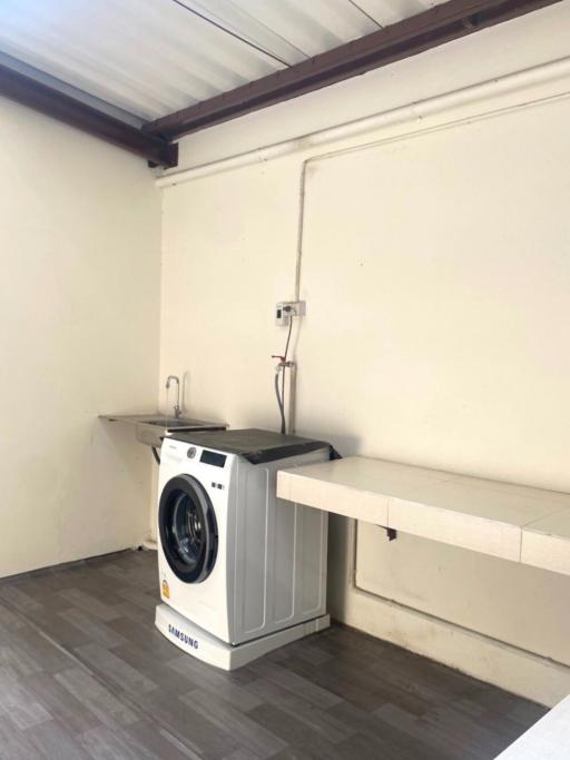 Compact laundry area with modern washing machine and built-in counter