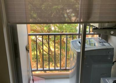 Small laundry area with washing machine on a balcony with natural light