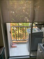 Small laundry area with washing machine on a balcony with natural light