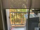 Small laundry area with washing machine on a balcony with natural light