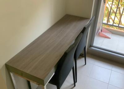 Minimalistic study area with a simple desk and chairs near a window with natural light