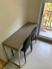 Minimalistic study area with a simple desk and chairs near a window with natural light