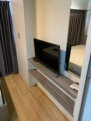 Compact modern bedroom with integrated entertainment unit and hardwood flooring