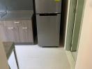 Compact kitchen with modern refrigerator and wooden cabinets