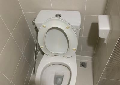 White ceramic toilet in a tiled bathroom