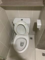 White ceramic toilet in a tiled bathroom