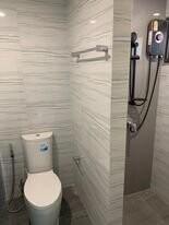 Modern bathroom with tiled walls and floors, equipped with a sleek white toilet and a wall-mounted shower system