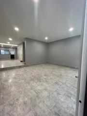 Spacious empty interior with tiled flooring and neutral color walls