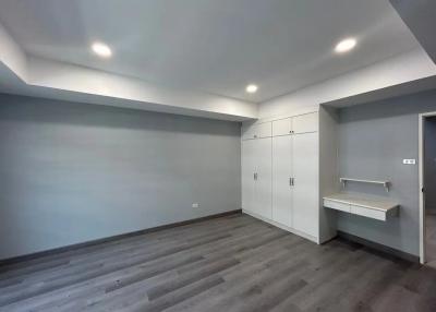 Spacious bedroom with built-in wardrobes and hardwood flooring