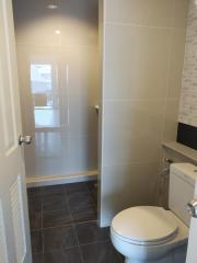 Modern bathroom interior with glass door shower and tiled walls