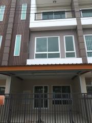 Modern residential building exterior with large windows and gated entry